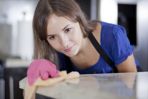 woman cleaning a glass table